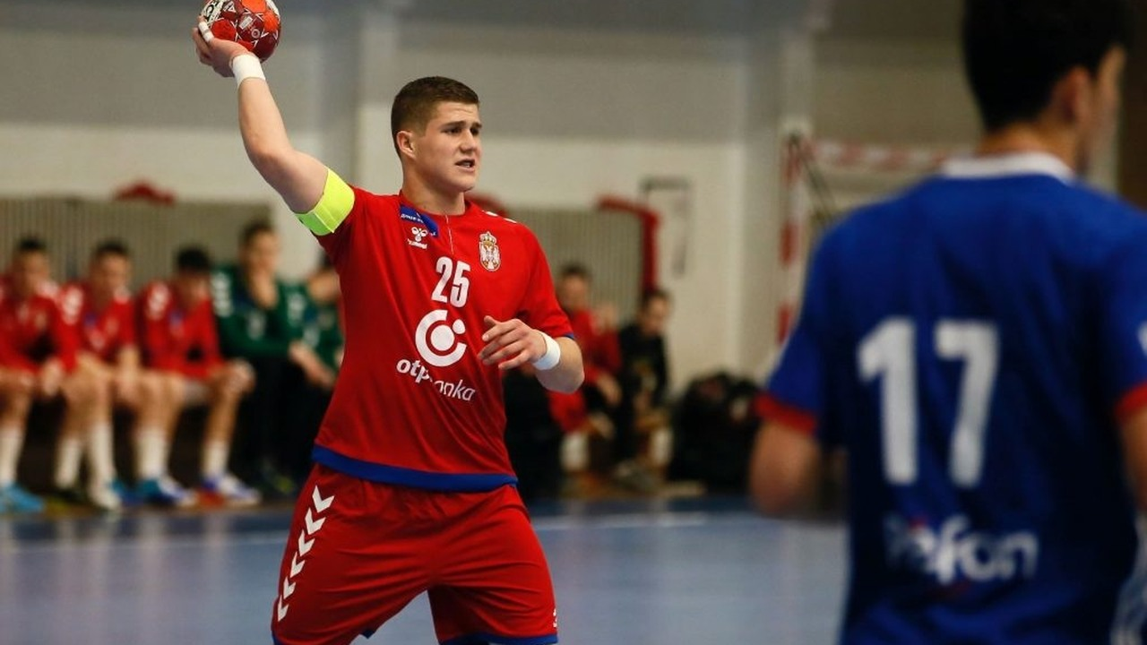 A Serbia under-18 handball player shoots during an international match