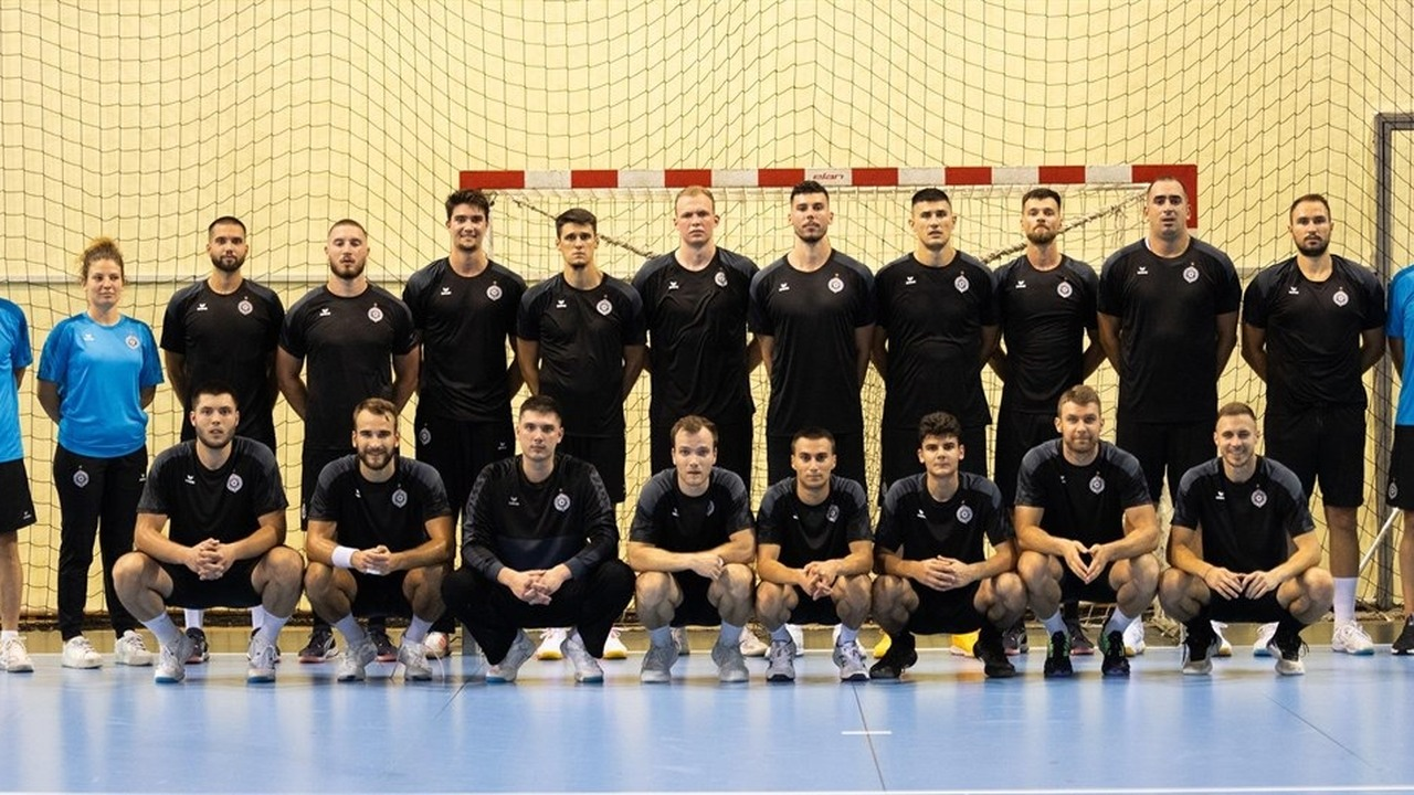 Partizan handball players and coaches pose for a team photograph