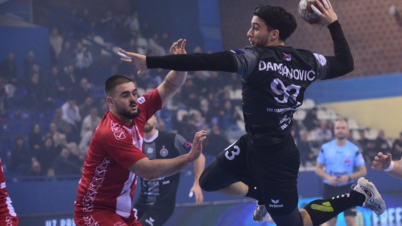 A Partizan handball player shoots over a defender