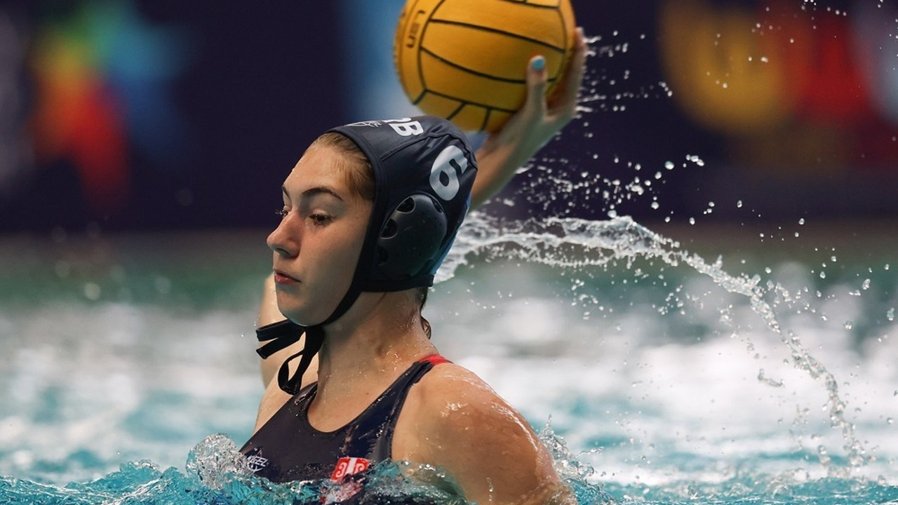 A Serbian junior water polo player prepares to pass the ball