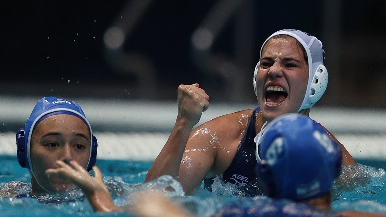 Serbian junior water polo players celebrate together in the pool