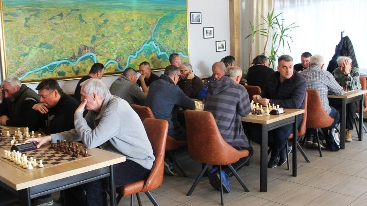 Players sit across several chessboards during a club tournament