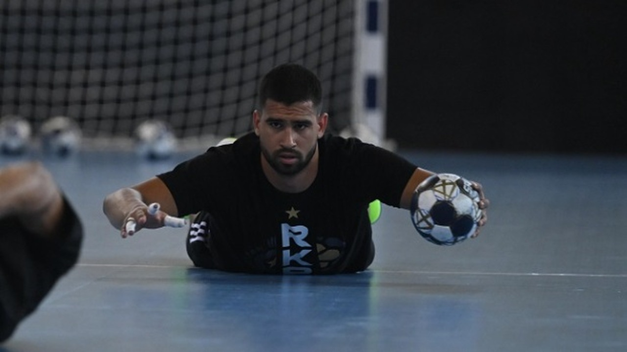 Milos Kos trains with a handball while wearing a dark Partizan top