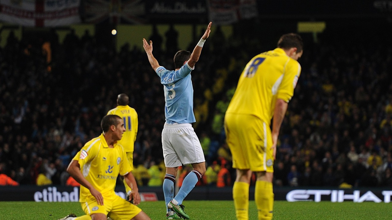 Aleksandar Kolarov raises his arms during a Manchester City match