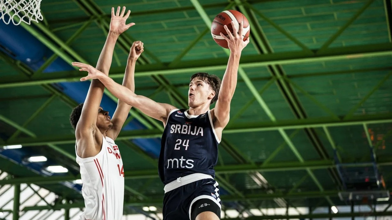 A Serbia basketball player attacks the basket against Denmark