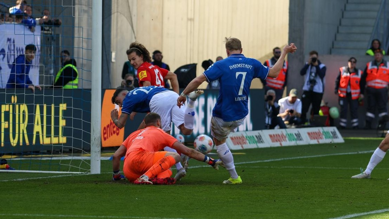 Darmstadt and Holstein Kiel players contest the ball during a league match