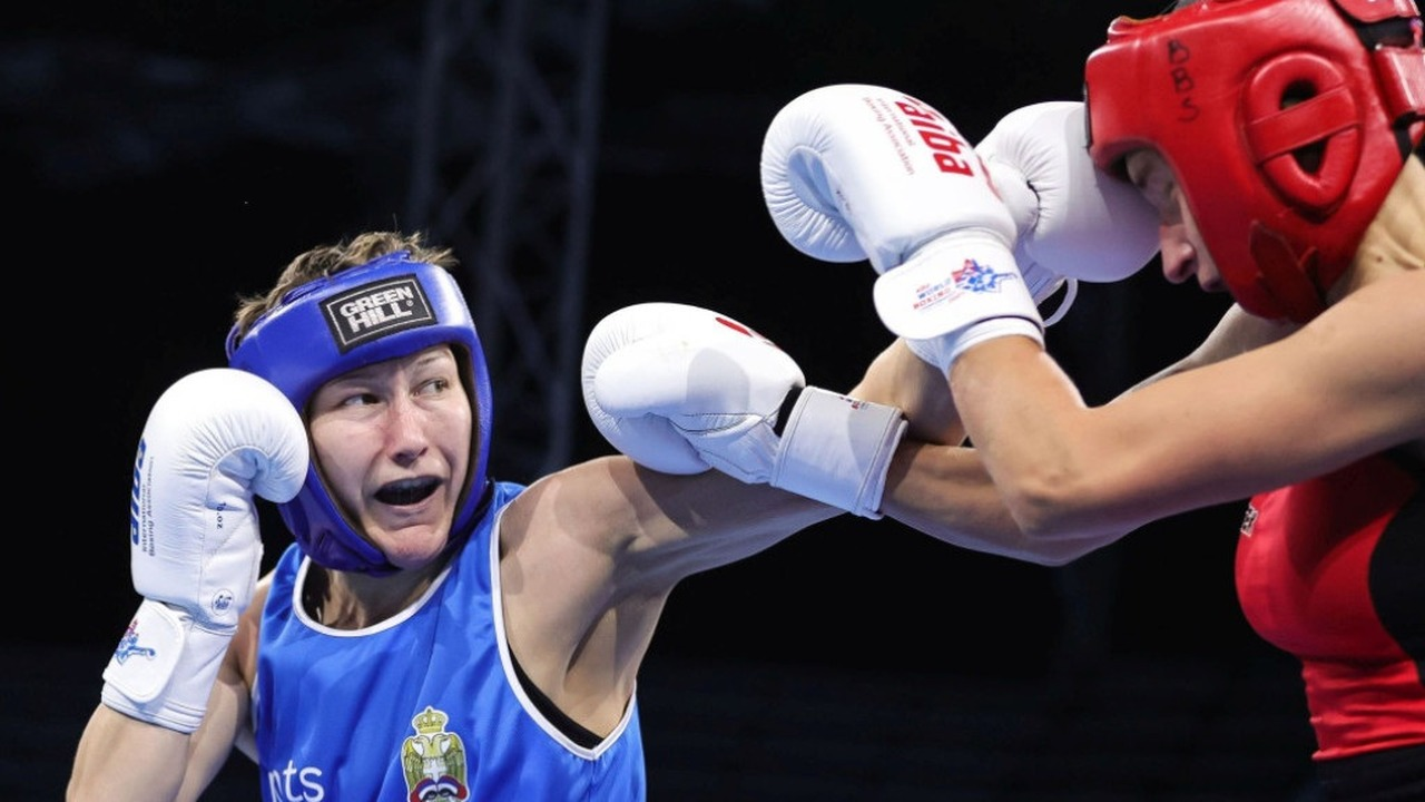Two women boxers exchange punches during a bout