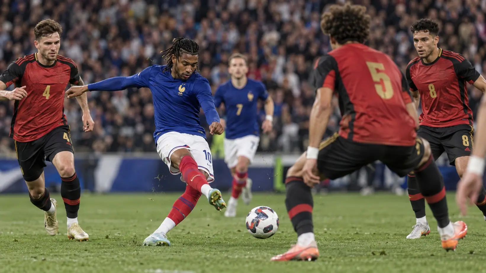 Majkl Olise šutira kroz belgijsku odbranu