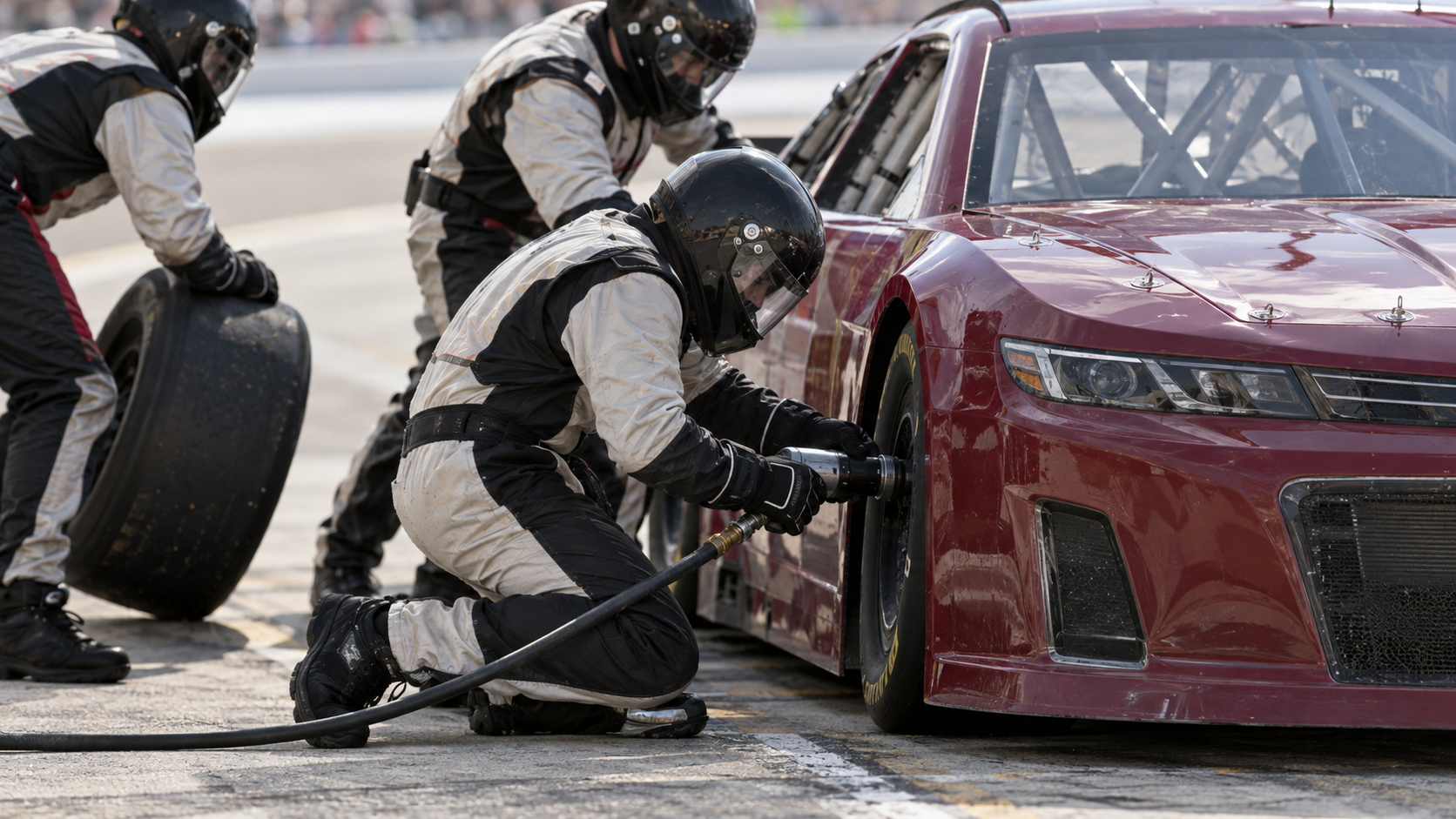 Ilustracija NASCAR trka: mehaničari menjaju gumu zatvorenog trkačkog automobila.